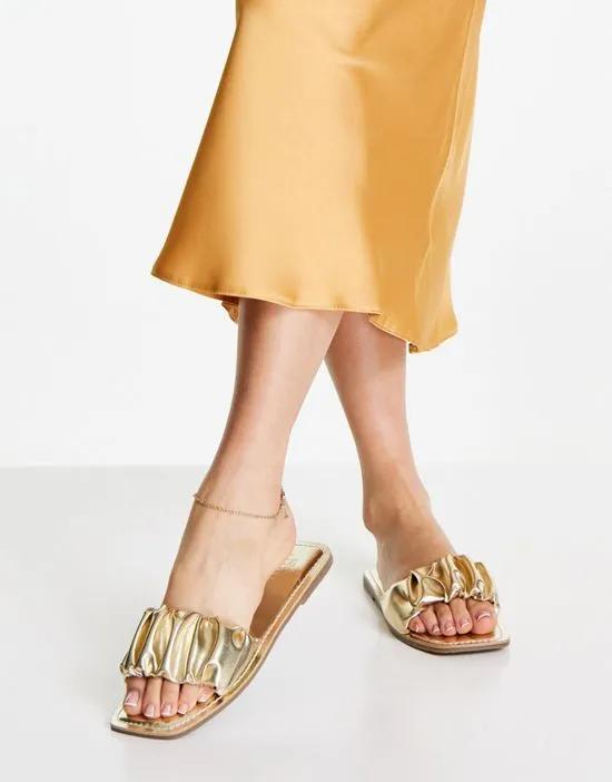 Favor ruched flat mules in gold