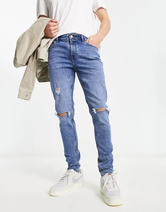 skinny jeans in mid wash blue with rips