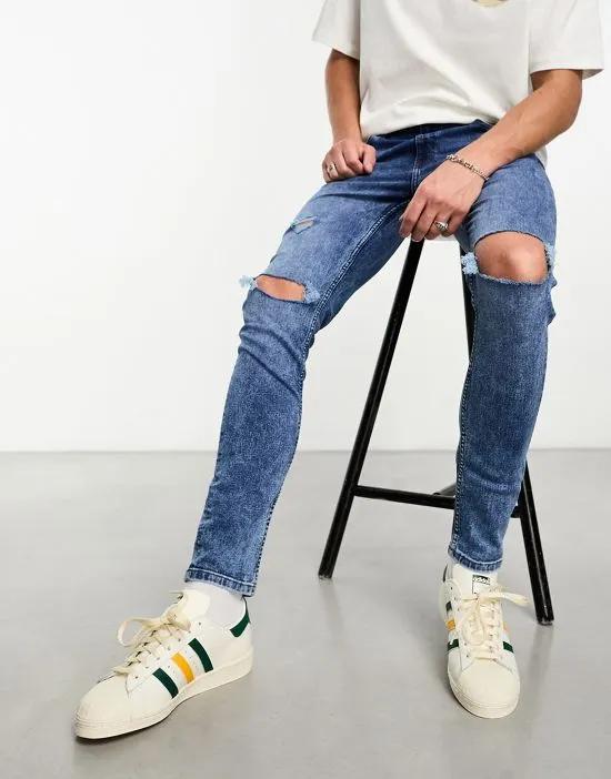 skinny jeans with knee rips in mid wash blue