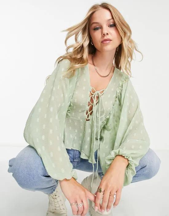 textured long sleeve blouse with lace up front & peplum hem in sage
