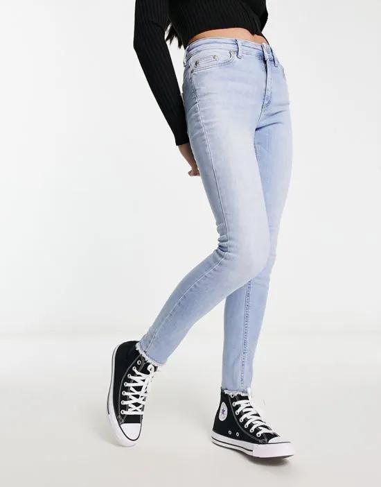 Blush skinny jeans with frayed hem in light blue