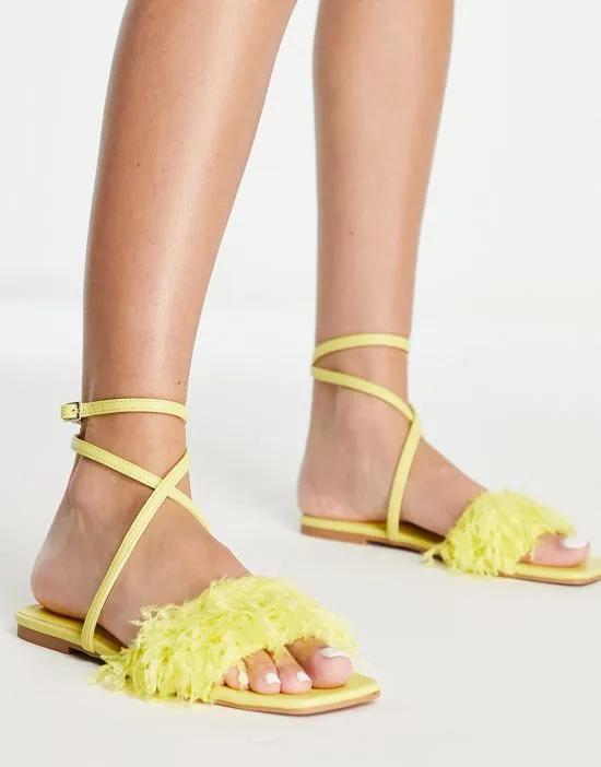 Four faux feather flat sandals in yellow