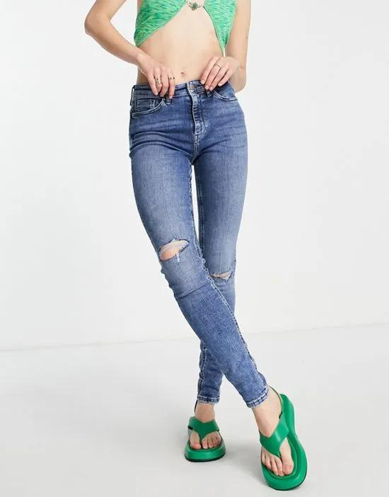 high rise skinny jean with distressing in mid blue