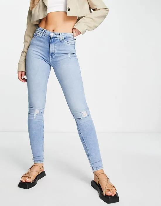 high rise skinny jeans with distressed knees in light wash