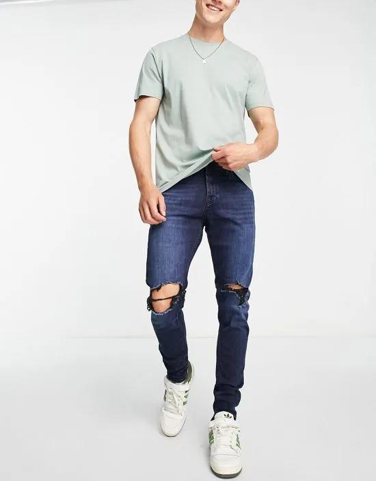 Intelligence Pete skinny carrot jeans with knee rips in blue black wash