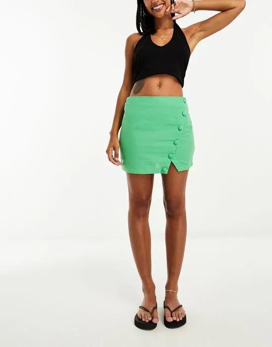 linen mini skirt with asymmetric button detail in bright green