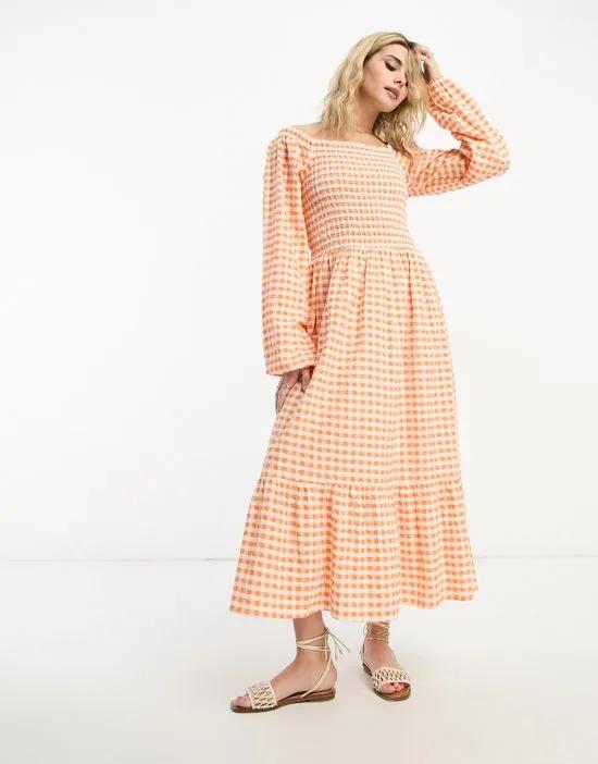 long sleeve midi dress with ruffled hem in orange gingham