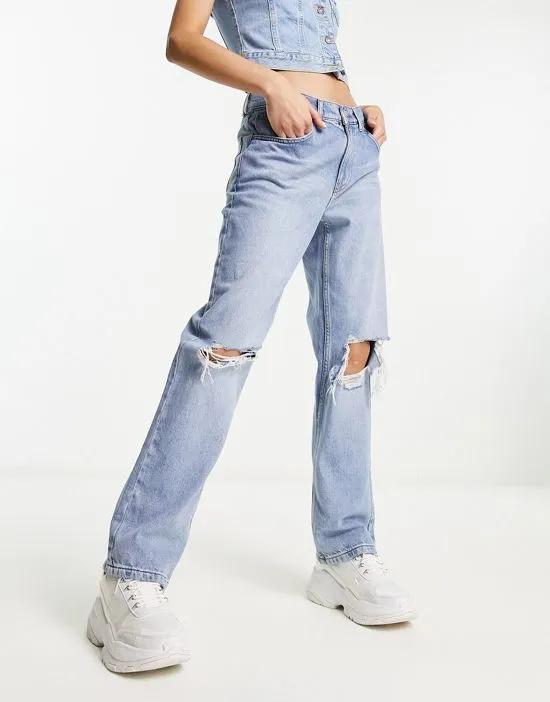 loose straight jeans with knee rips in light blue