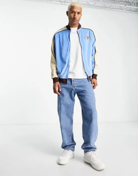 oversized retro velour bomber jacket in blue and beige with chest embroidery