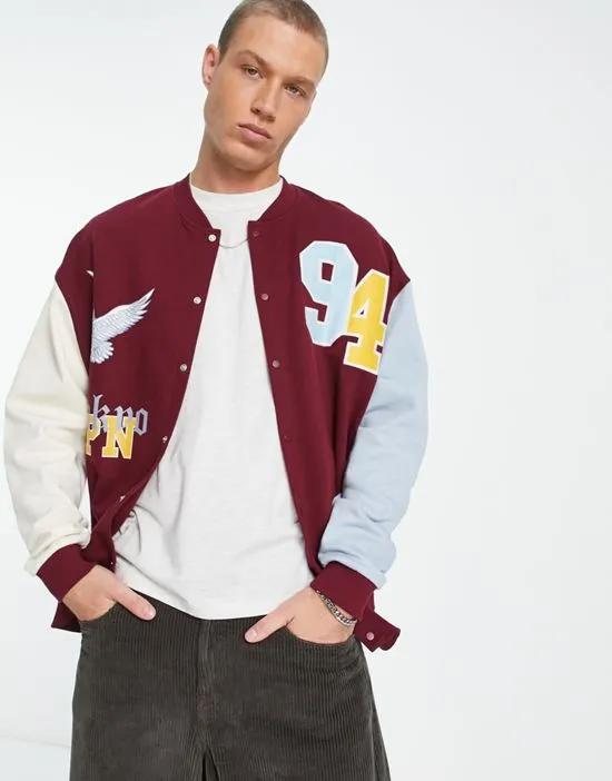oversized varsity jacket in burgundy color block with badging