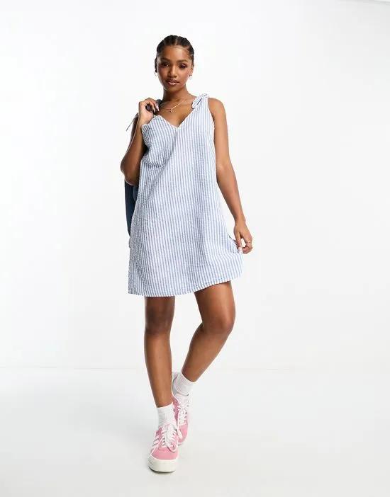 seersucker bow tie strap mini dress with side pockets in blue and white stripe