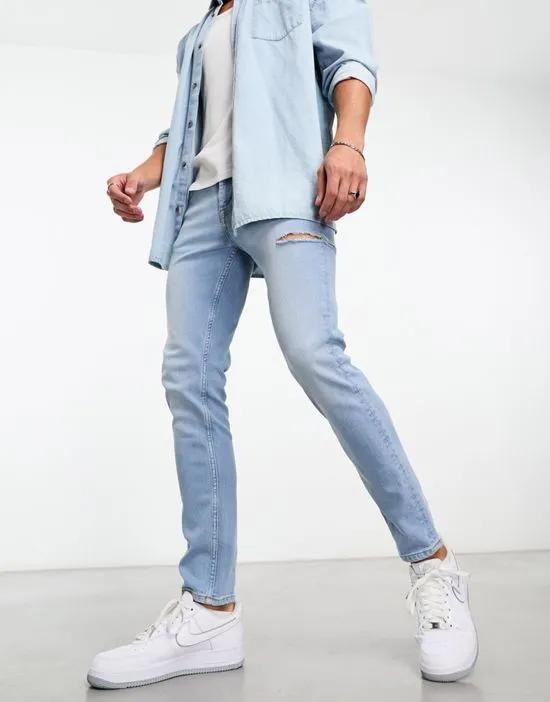 skinny jeans in light wash blue with thigh rip
