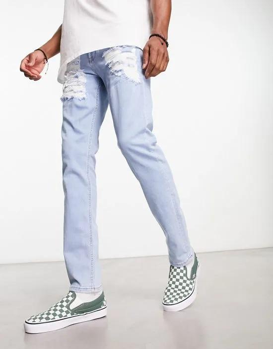 skinny jeans with heavy rips in light wash blue