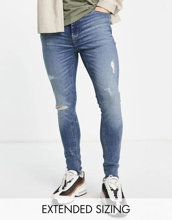 spray on jeans with power stretch in mid wash blue with tint and abrasions