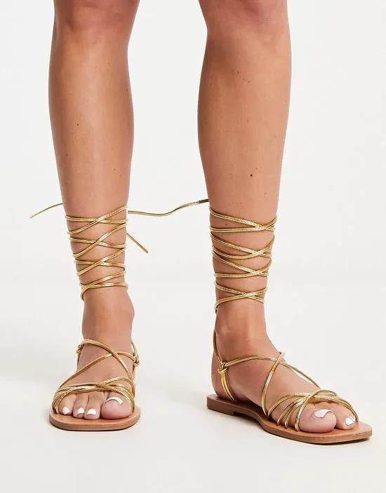 strappy tie leg flat sandals in gold metallic