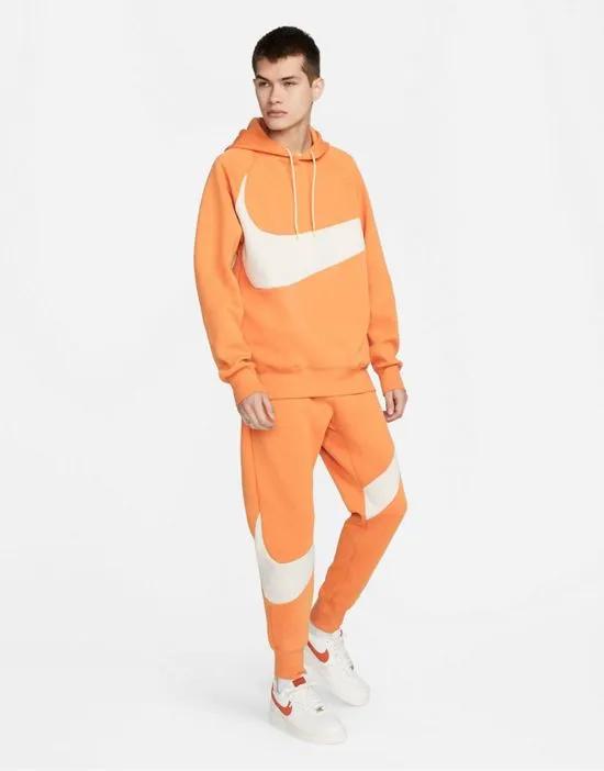 Swoosh Pack Tech Fleece cuffed sweatpants in orange