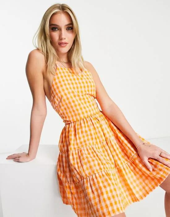 tiered mini cami dress with bow back in orange gingham