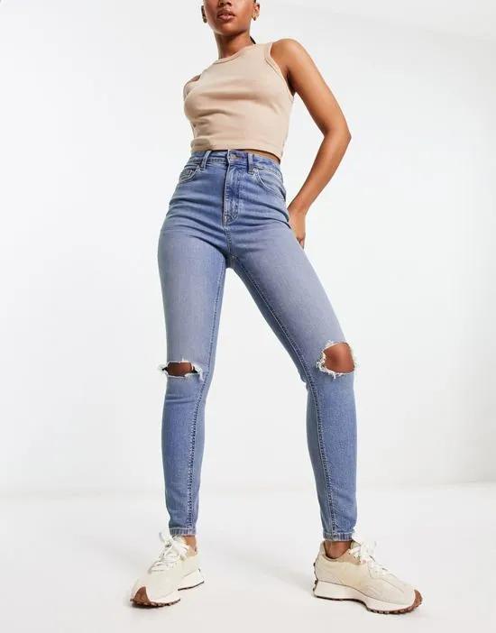 ultimate skinny jean in mid blue with knee rips