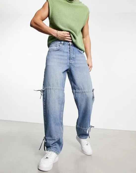 wide straight leg jeans with tie details in mid wash blue
